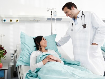 Krankenhauszusatzversicherung: Frau beim Arztgespräch im Einbettzimmer