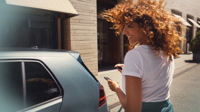 Kfz-Versicherung: Junge Frau mit Autoschlüsse an Ihrem Fahrzeug