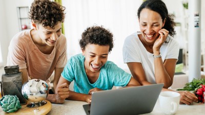 Jugendliche lachend vor einem Laptop