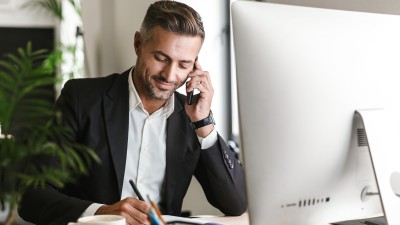 Mythen und Irrtümer über Unternehmervorsorgevollmachten: Mann sitzt am Computer und telefoniert.