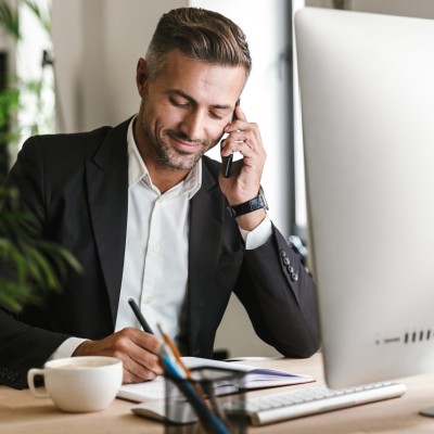 Mythen und Irrtümer über Unternehmervorsorgevollmachten: Mann sitzt am Computer und telefoniert.