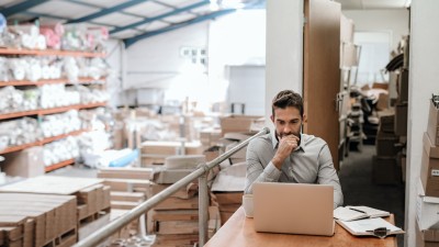 Produktsicherheitsverordnung (GPSR) 2024 - Was Unternehmen jetzt wissen müssen: Manager, der online arbeitet, während er in einem Lagerbüro sitzt 