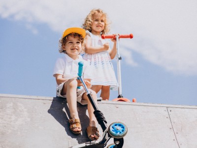 Versicherung kinderleicht? : Zwei Kinder sind mit ihren Scootern in der Halfpipe