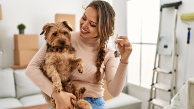 Das müssen Sie sich nicht gefallen lassen - 8 ungültige Klauseln im Mietvertrag: Frau zeigt ihrem Hund den neuen Wohnungsschlüssel