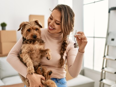 Das müssen Sie sich nicht gefallen lassen - 8 ungültige Klauseln im Mietvertrag: Frau zeigt ihrem Hund den neuen Wohnungsschlüssel