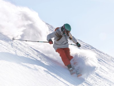 Frau fährt mit Ski den Berg hinunter