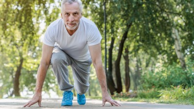 Fit in den Frühling - Wie Bewegung im Freien den Körper und die Psyche stärkt: Mann in Startblock-Position zum Sprint