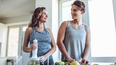 Jung und unbeschwert? So denken junge Erwachsene über ihre Gesundheitsvorsorge : Junges sportliches Paar kocht gesund