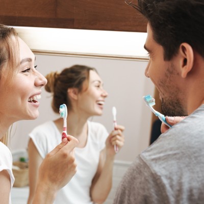 Zähne aufhellen mit Hausmitteln - Mythos oder natürliche Wunderwaffe?: Paar putzt sich die Zähne