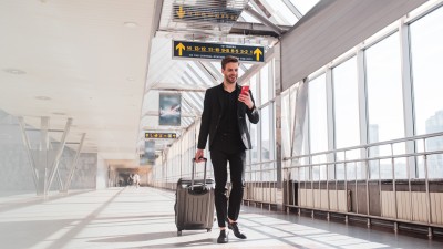 Tipps und Tricks für ein einzigartiges Work and Travel Erlebnis: Ein junger Mann zieht einen Koffer am Flughafen.