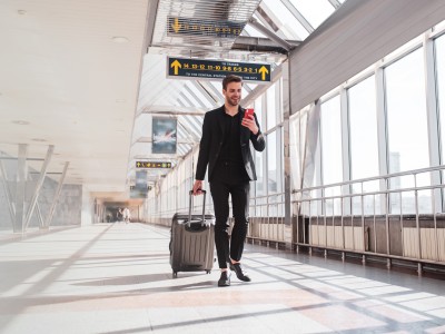 Tipps und Tricks für ein einzigartiges Work and Travel Erlebnis: Ein junger Mann zieht einen Koffer am Flughafen.