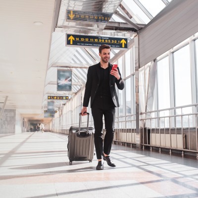Tipps und Tricks für ein einzigartiges Work and Travel Erlebnis: Ein junger Mann zieht einen Koffer am Flughafen.