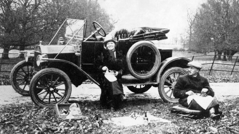 Schwarz-wei&szlig; Foto von einem Ehepaar und seinem Ford-Auto im Jahr 1913