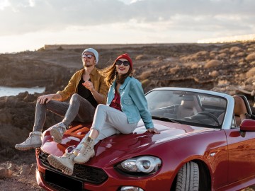 Paar mit Cabrio am Strand