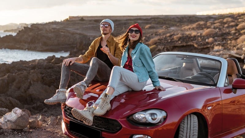 Paar mit Cabrio am Strand