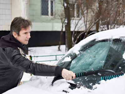 Autofahren im Herbst und Winter – Faktencheck: Mann entfernt Schnee von Auto