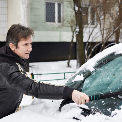 Autofahren im Herbst und Winter – Faktencheck: Mann entfernt Schnee von Auto