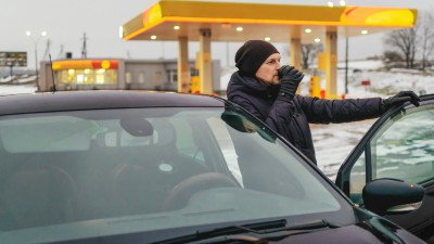 Unfallgefahr Sekundenschlaf: Mann macht Pause von der Autofahrt an einer Tankstelle