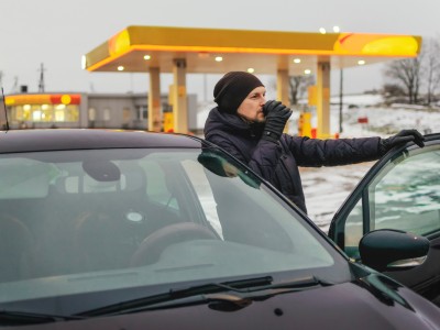 Unfallgefahr Sekundenschlaf: Mann macht Pause von der Autofahrt an einer Tankstelle