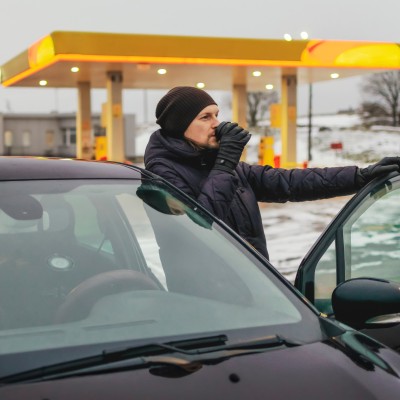 Unfallgefahr Sekundenschlaf: Mann macht Pause von der Autofahrt an einer Tankstelle