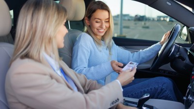 Führerschein umtauschen - Fristen von 2026 bis 2033 - das müssen Sie wissen: Frau &uuml;bergibt im Auto einer jungen Fahrerin den F&uuml;hrerschein