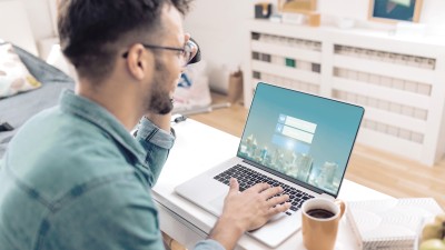 10 Tipps, die Ihr Home-Office vor Hackern schützen: Ein junger Mann loggt sich sicher auf einem Laptop ein