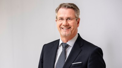 Mann in blauem Anzug lächelt in Kamera