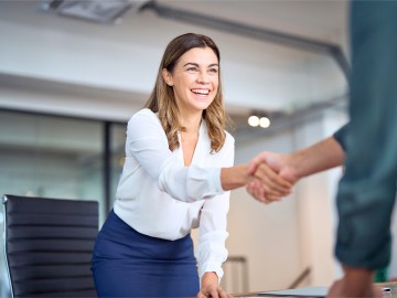 Eine Gesch&auml;ftsfrau gibt einer anderen Person die Hand