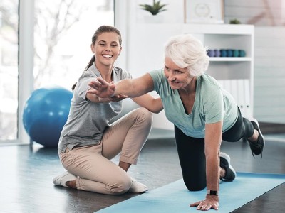 Wellness & Gesundheit: Eine Fitnesstrainerin coacht eine ältere Frau