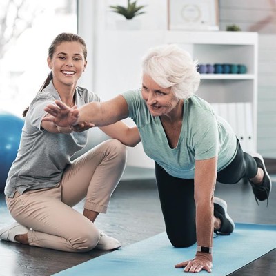 Wellness & Gesundheit: Eine Fitnesstrainerin coacht eine &auml;ltere Frau