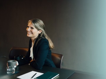 Rechtsanwälte & Steuerberater: Frau im Businessanzug am Konferenztisch