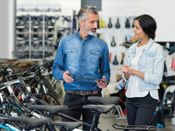 Fahrradhändler & -werkstatt: Fahrradh&auml;ndler im Verkaufsgespr&auml;ch in seinem Gesch&auml;ft