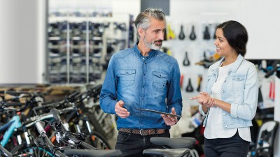 Fahrradhändler & -werkstatt: Fahrradhändler im Verkaufsgespräch in seinem Geschäft