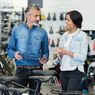 Fahrradhändler & -werkstatt: Fahrradhändler im Verkaufsgespräch in seinem Geschäft