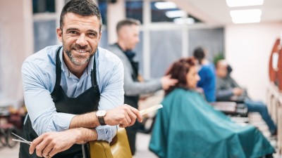 Friseure: Friseur föhnt Kundin die Haare