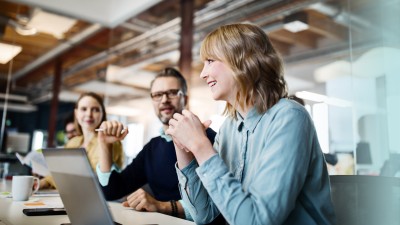 Betriebliche Berufsunfähigkeitsversicherung: Mitarbeiter sehen sich Ergebnisse auf Laptop an