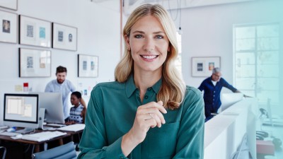 Betriebliche Krankenversicherung: Frau vor Bürokulisse