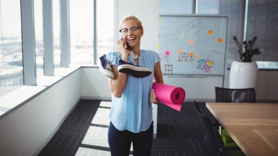 Frau mit Handy und Sportutensilien