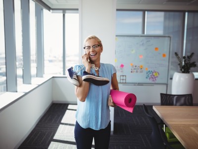 Frau mit Handy und Sportutensilien