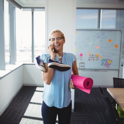 Frau mit Handy und Sportutensilien