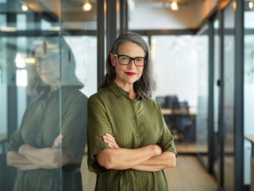 Firmenrechtsschutz: Eine Frau zeigt einem Mann etwas auf Ihrem Tablet vor einem Firmengebäude