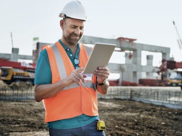 Kautionsversicherung für Ihr Gewerbe: Bauarbeiter mit Tablet