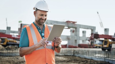 Kautionsversicherung: Bauarbeiter mit Tablet