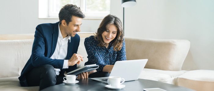 Ein Mann und eine Frau beim Beratungsgespr&auml;ch mit Laptop im Wohnzimmer