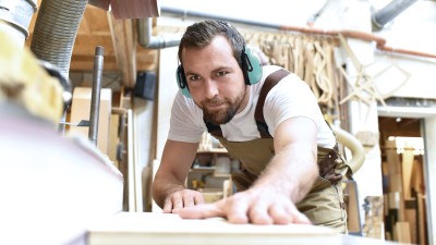 Schreiner mit Gehörschutz bei der Arbeit