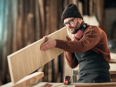 Schreiner überprüft sein zu verarbeitendes Brett 