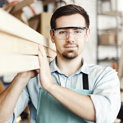 Schreiner trägt Holzbalken