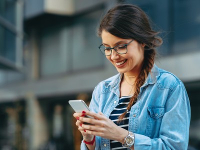 Zahlt die Haftpflicht bei kaputtem Handy?  : Frau mit Handy