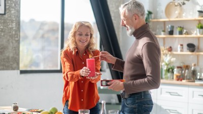 Paar zündet Kerze in der Küche an