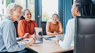 Mitarbeiterinnen im Büro mit Laptop an einem Besprechungstisch